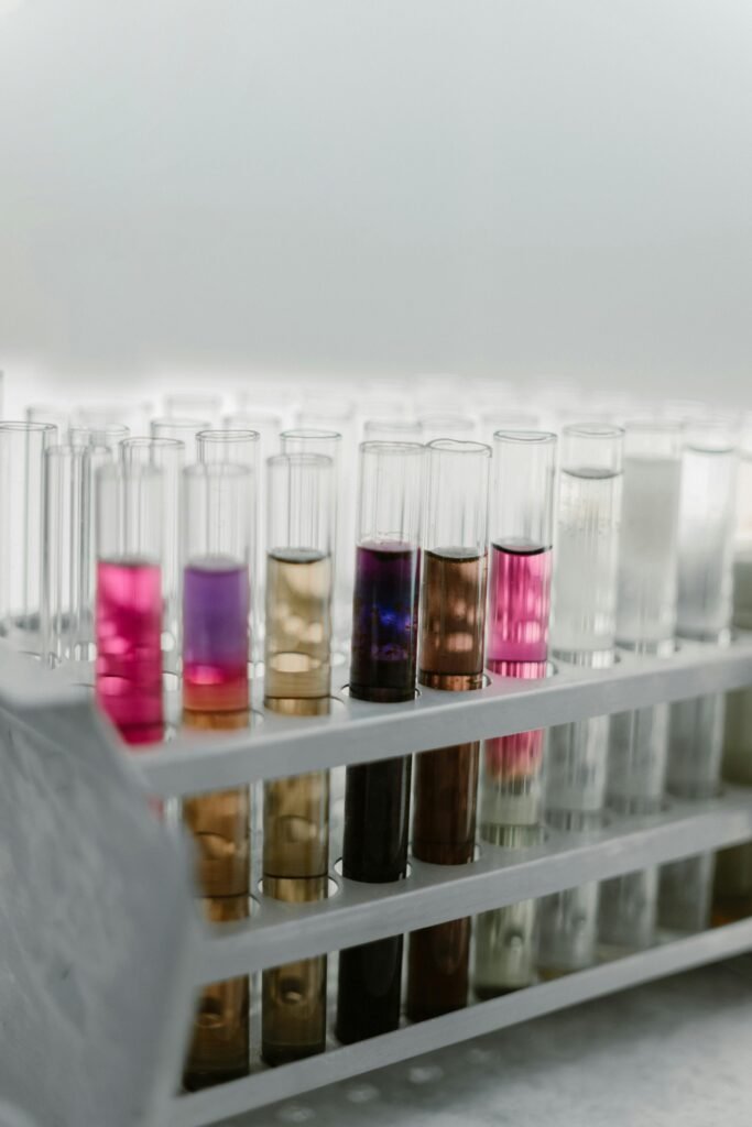 Close-up of colorful chemical solutions in test tubes, arranged in a rack for scientific analysis.